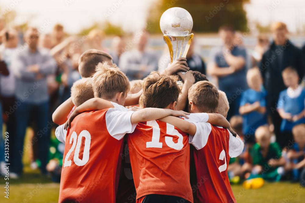 Jong voetbalteam houdt gewonnen beker vast