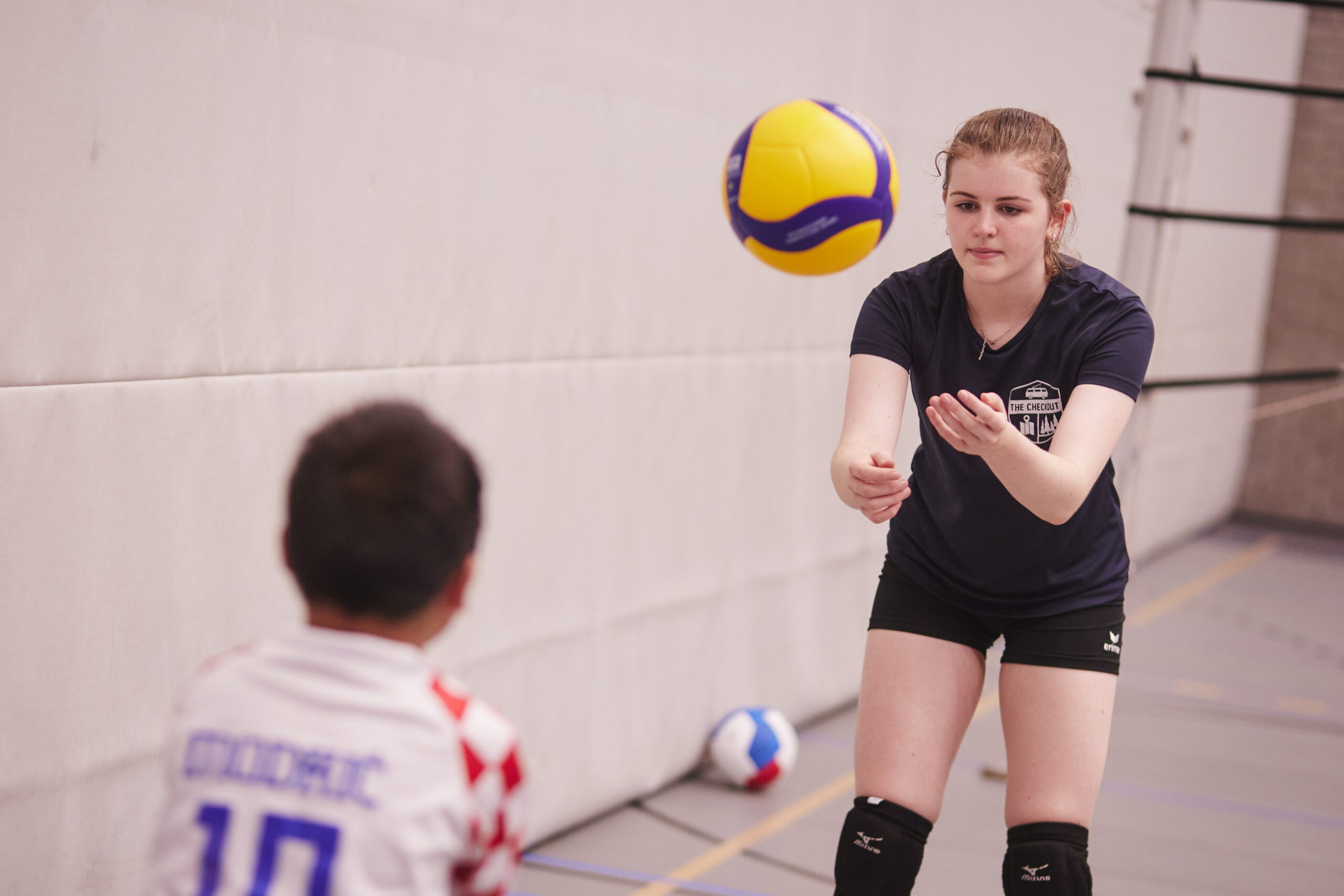 Meisje en jongen spelen een volleybal heen en weer