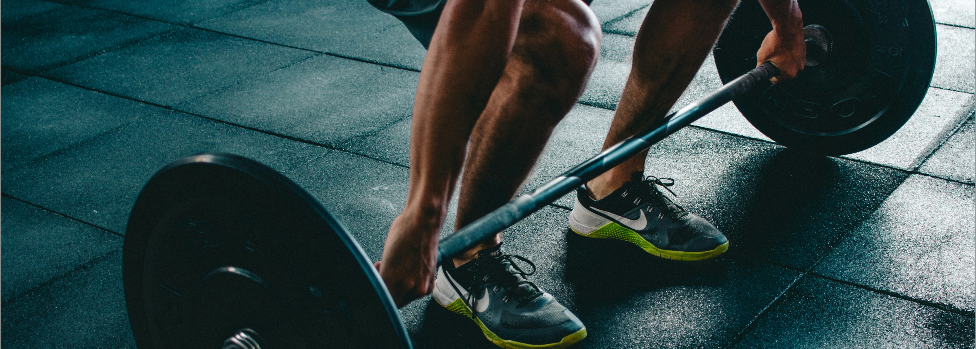 Man doet deadlifts op matten in sportschool