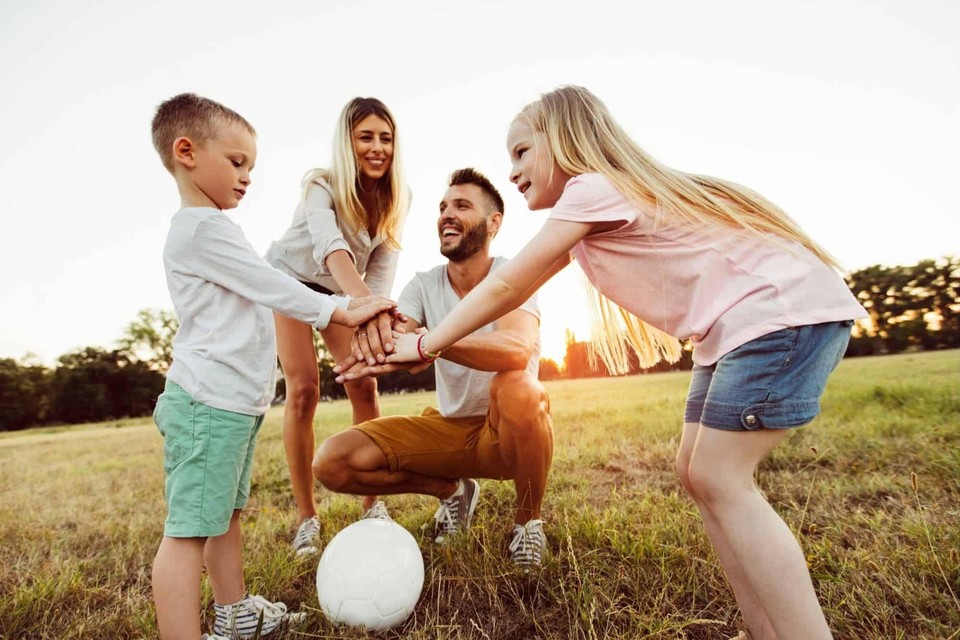 Een gezin met een voetbal op een grasveld